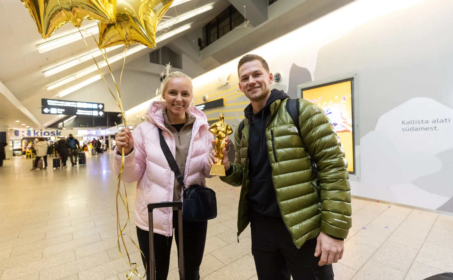Marie Kaldvee ja Harri Lill võtmas Tallinna lennujaamas vastu aasta võistkonna kuldset Kristjanit.