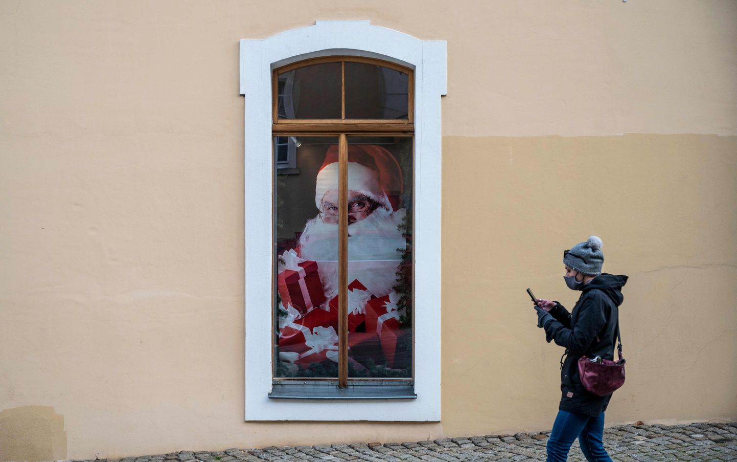 Девушка в маске идет мимо Санта Клауса в Германии. Фото иллюстративное.
