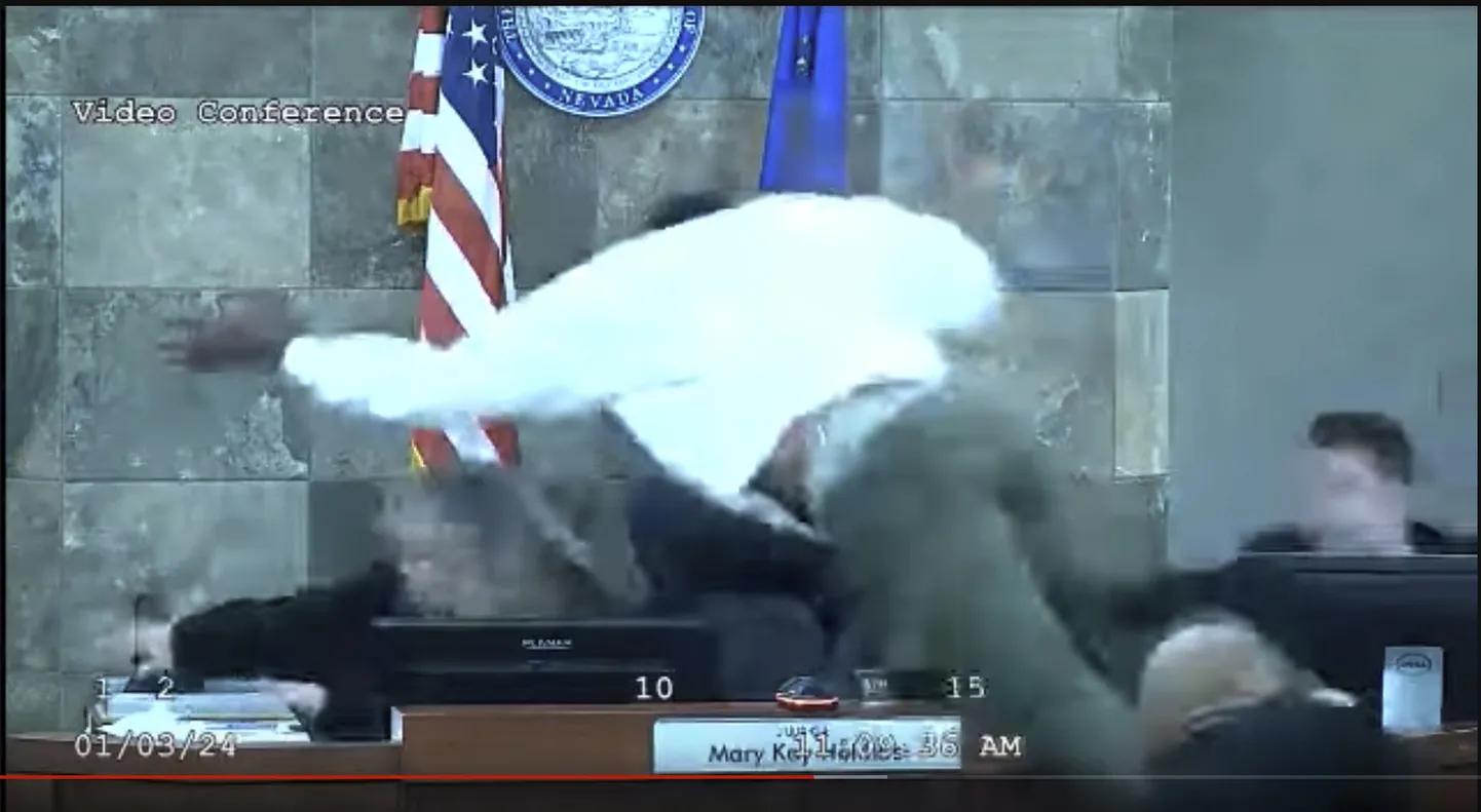 Mees ründas Las Vegase piirkonna kohtunikku, hüpates üle laua talle otse peale.(Clark County District Court via AP)  NYMV207
