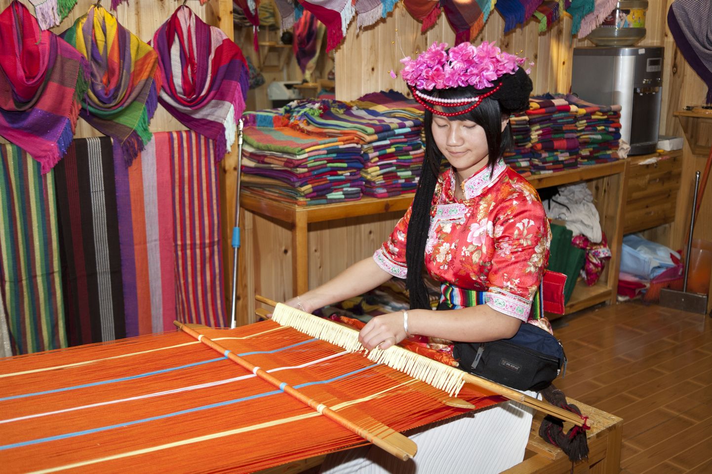 ORIGINAL:

Mosuo woman weaving colourful clothing in her shop, Lijiang, Yunnan Province, China