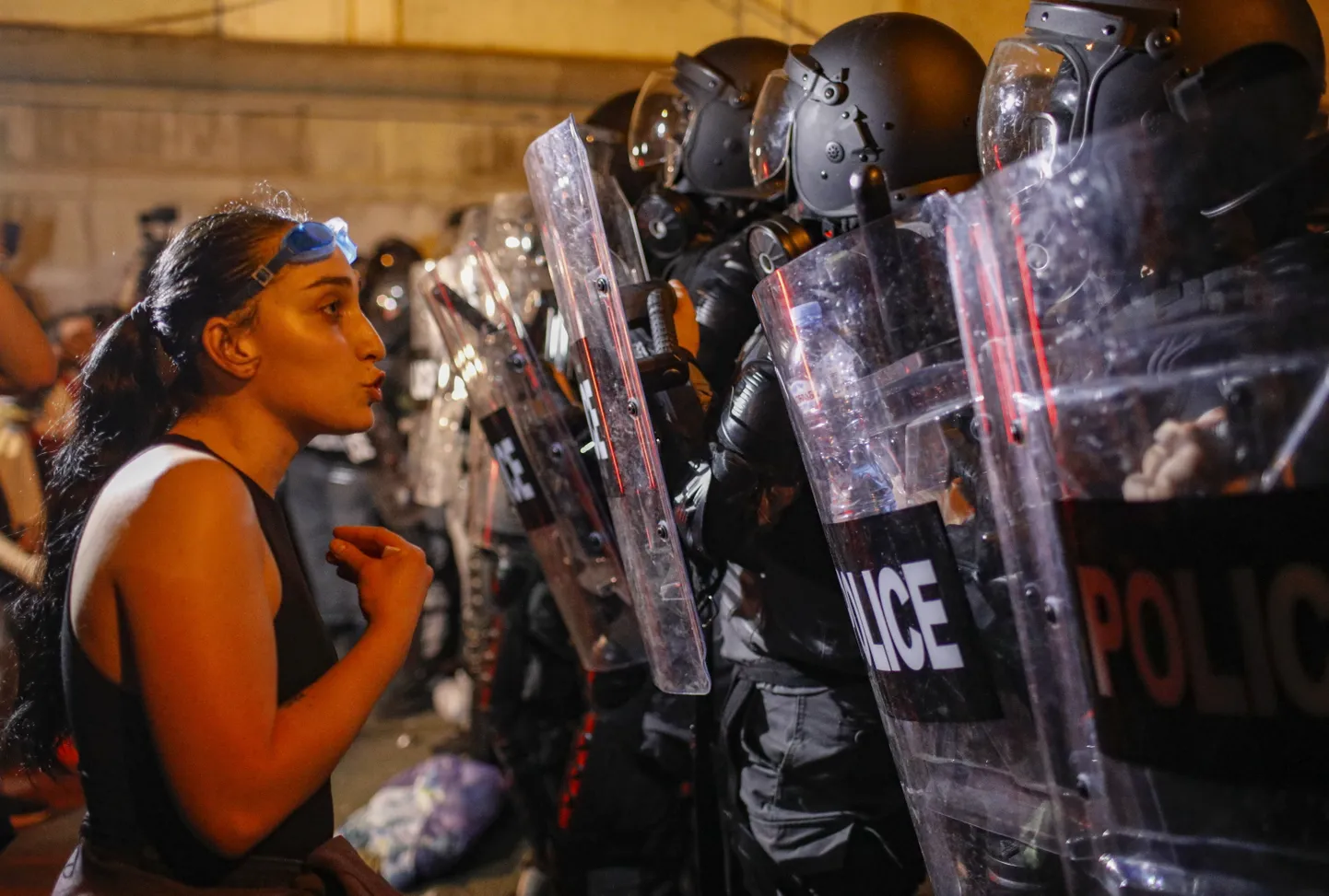Девушка разговаривает с полицейскими, блокирующими улицу во время акции протеста в грузинской столице, Тбилиси, 30 апреля 2024 года.