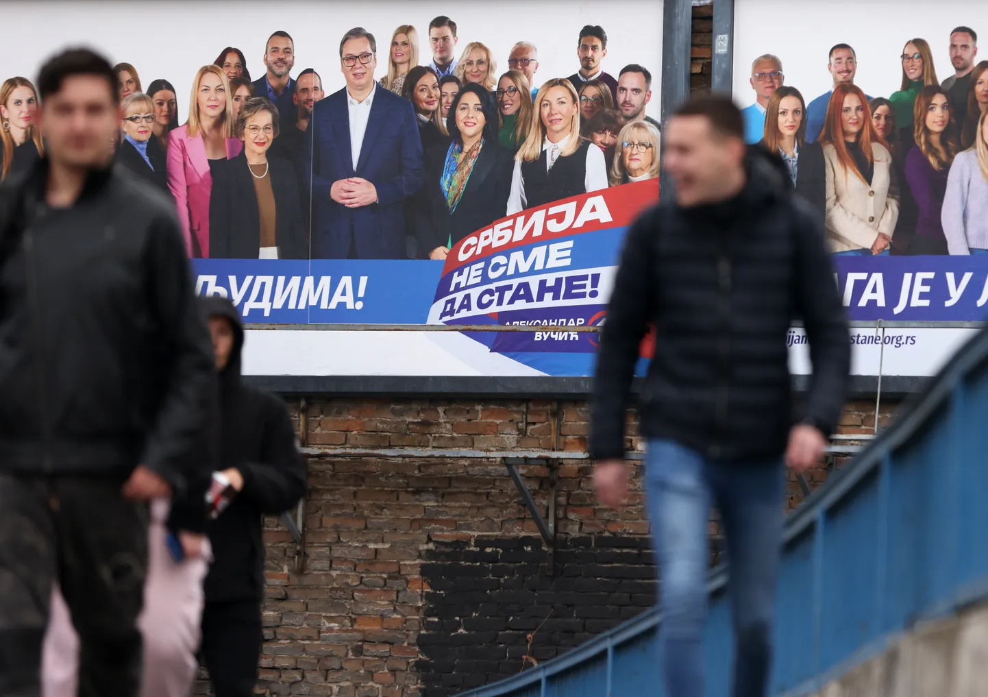 epa11031041 People walk past an election billboard of Serbian Progressive Party (SNS) in Belgrade, Serbia, 15 December 2023. Voters in Serbia will elect a new parliament and local authorities in 64 municipalities on 17 December 2023.  EPA/ANDREJ CUKIC