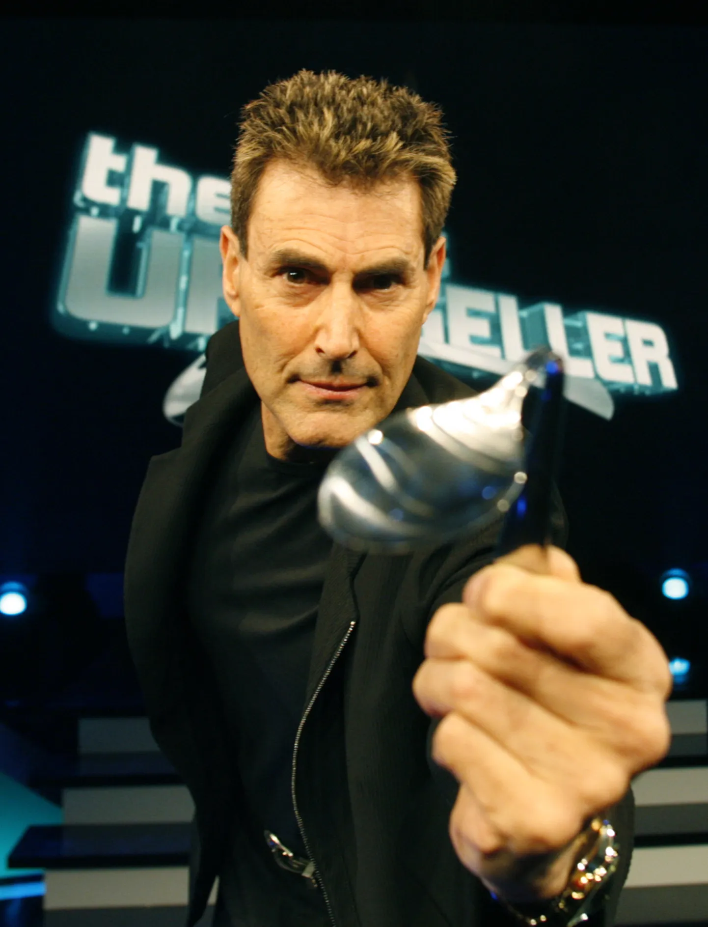 Iisareli-Briti illusionist Uri Geller 2008. aastal Saksamaal Kölnis meedia ees psüühilise jõuga lusikat painutamas