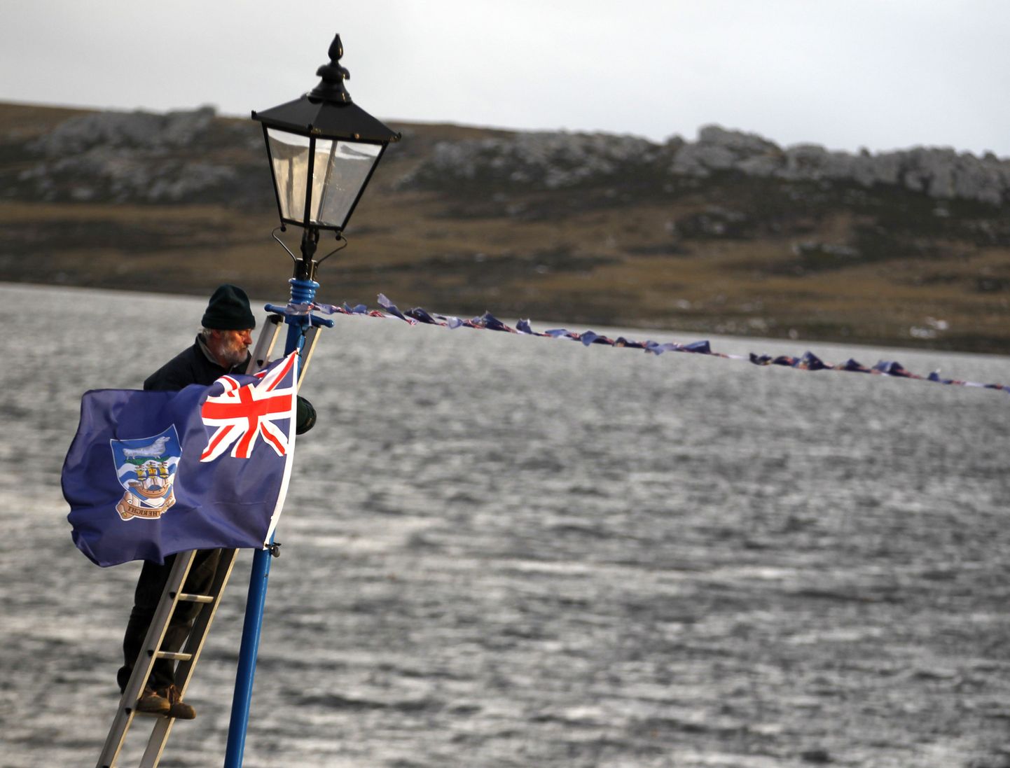 Mees heiskab Stanleys Falklandi saarte lippu.