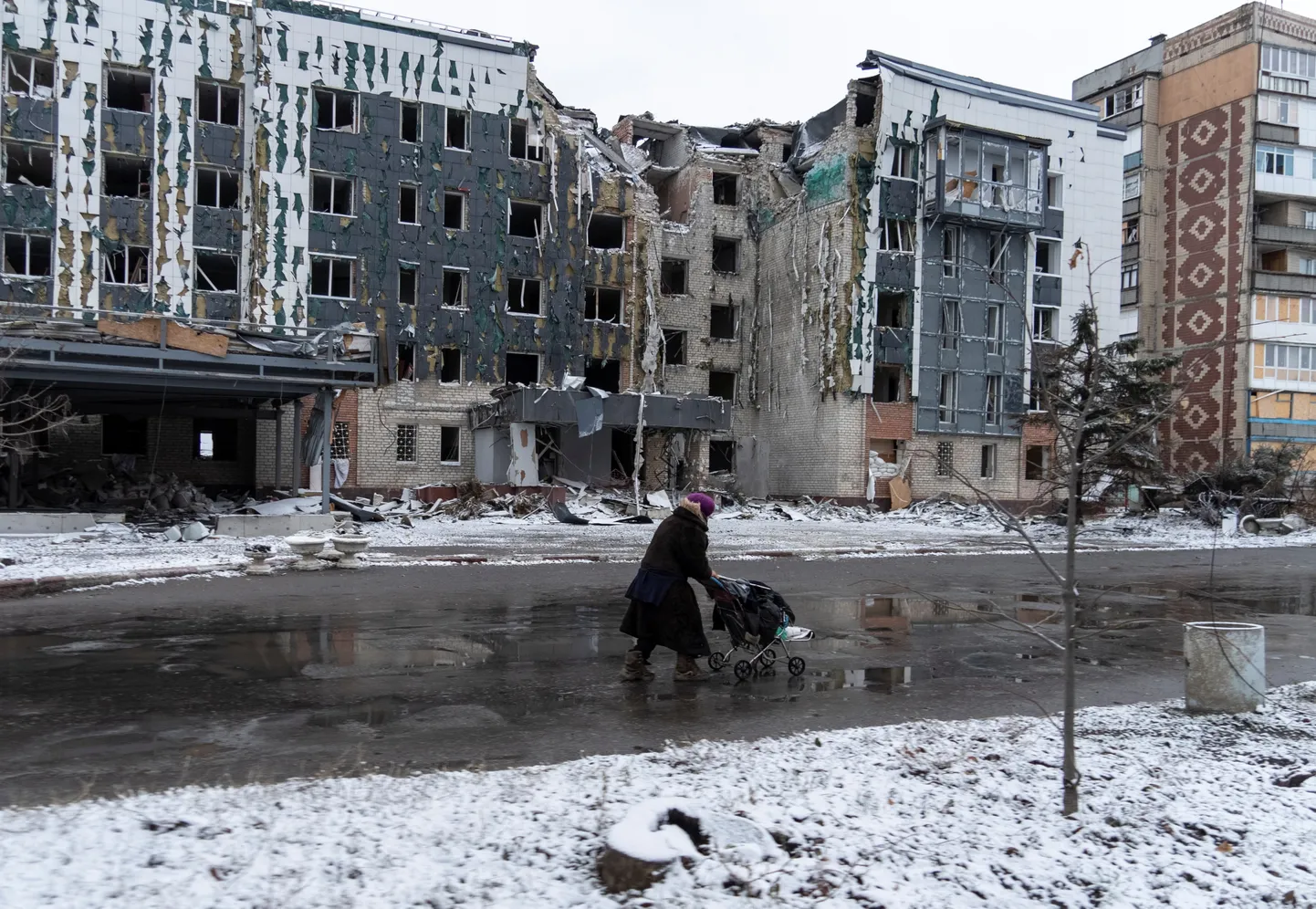 Женщина проходит мимо разрушенных домов в прифронтовом городе Покровск.