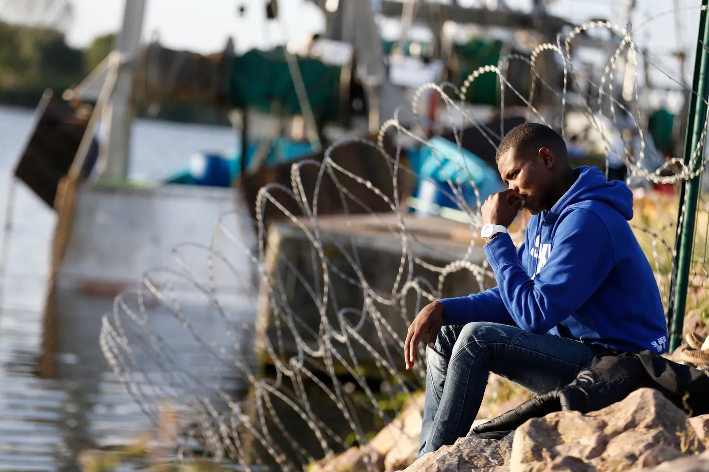 Migrants wait on the side of a road near the Brittany ferry port in Ouistreham, northwestern France, on September 18, 2018. - Ports along the French coastline are the final chance for migrants to illegally stowaway, hidden in vehicles travelling across the Channel to Britain.
