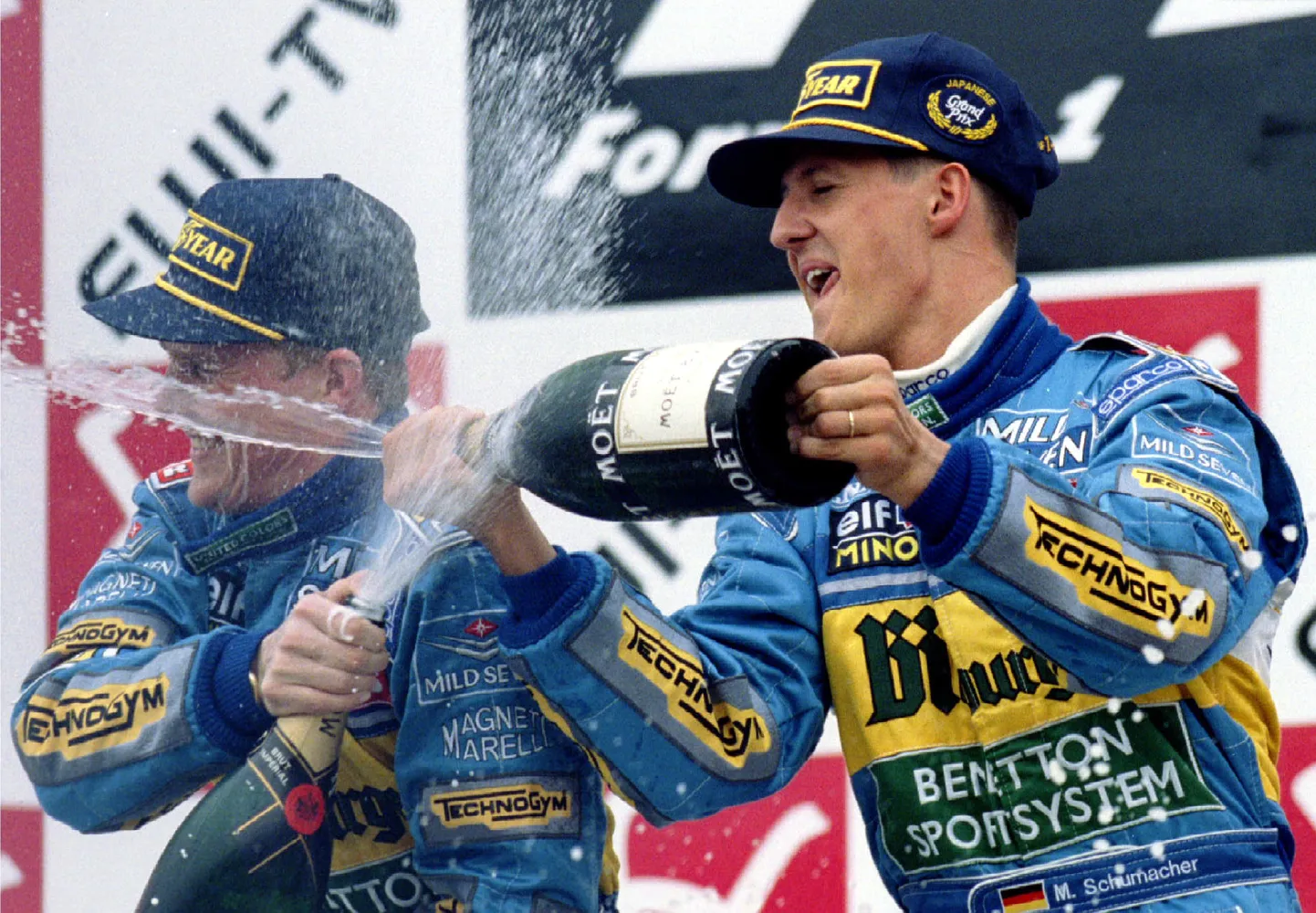 Michael Schumacher (paremal) ja Johnny Herbert pritsimas Suzuka ringrajal teineteist šampusega.
