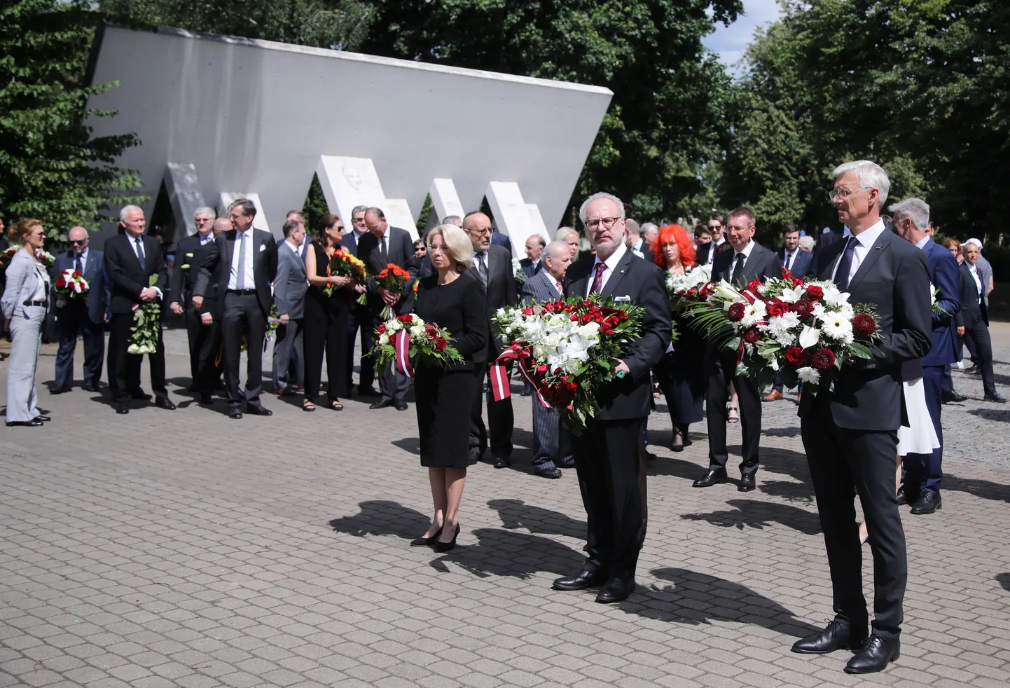 Ministru prezidents Krišjānis Kariņš (no labās), valsts prezidents Egils Levits un Saeimas priekšsēdētāja Ināra Mūrniece piedalās Ebreju tautas genocīda upuru piemiņas dienai veltītajā ziedu nolikšanas ceremonijā Rīgas Horālās sinagogas memoriālā.