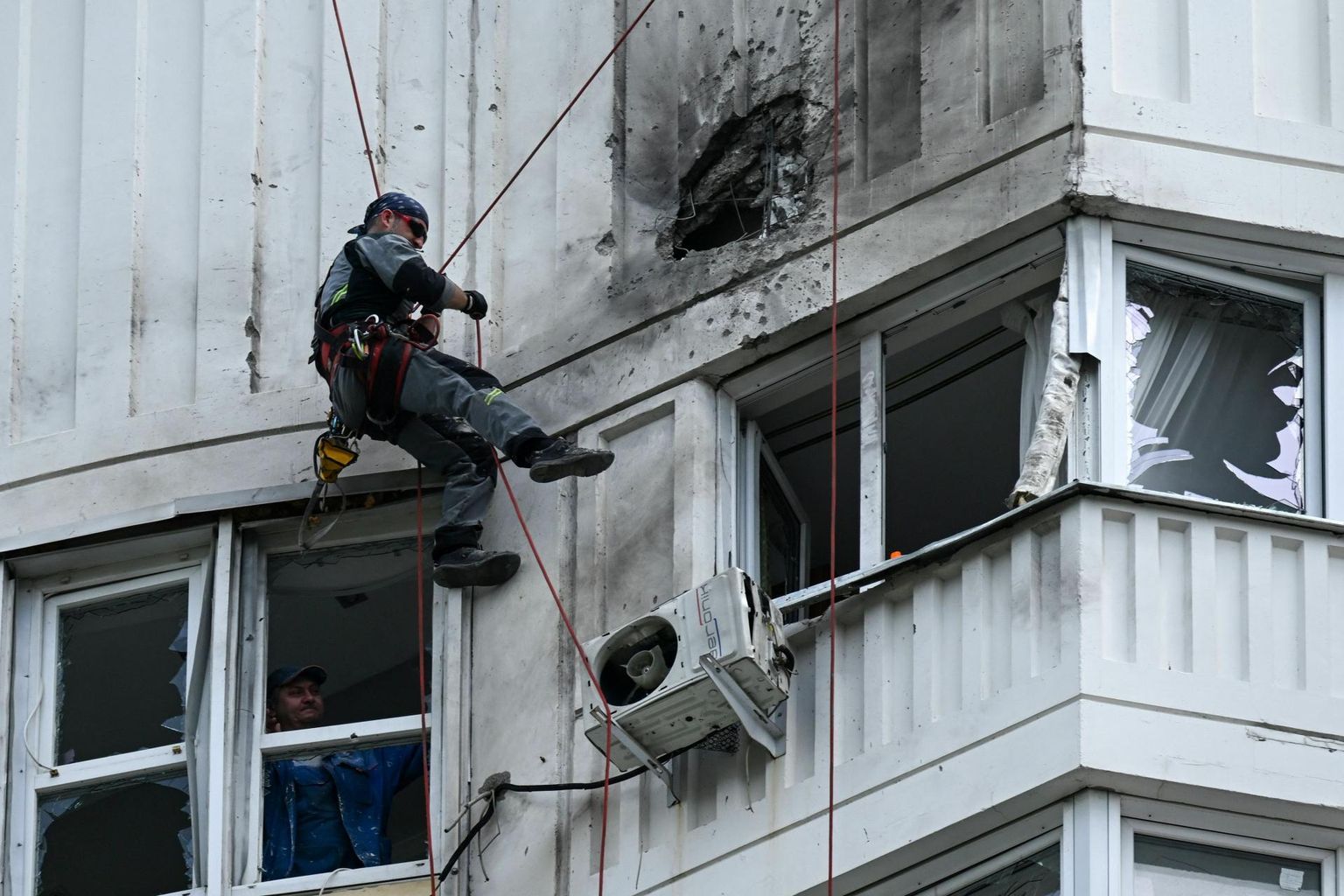 Tööline vaatab üle kahjustusi, mille tekitas droonirünnak eile ühele Moskva kortermajale. 