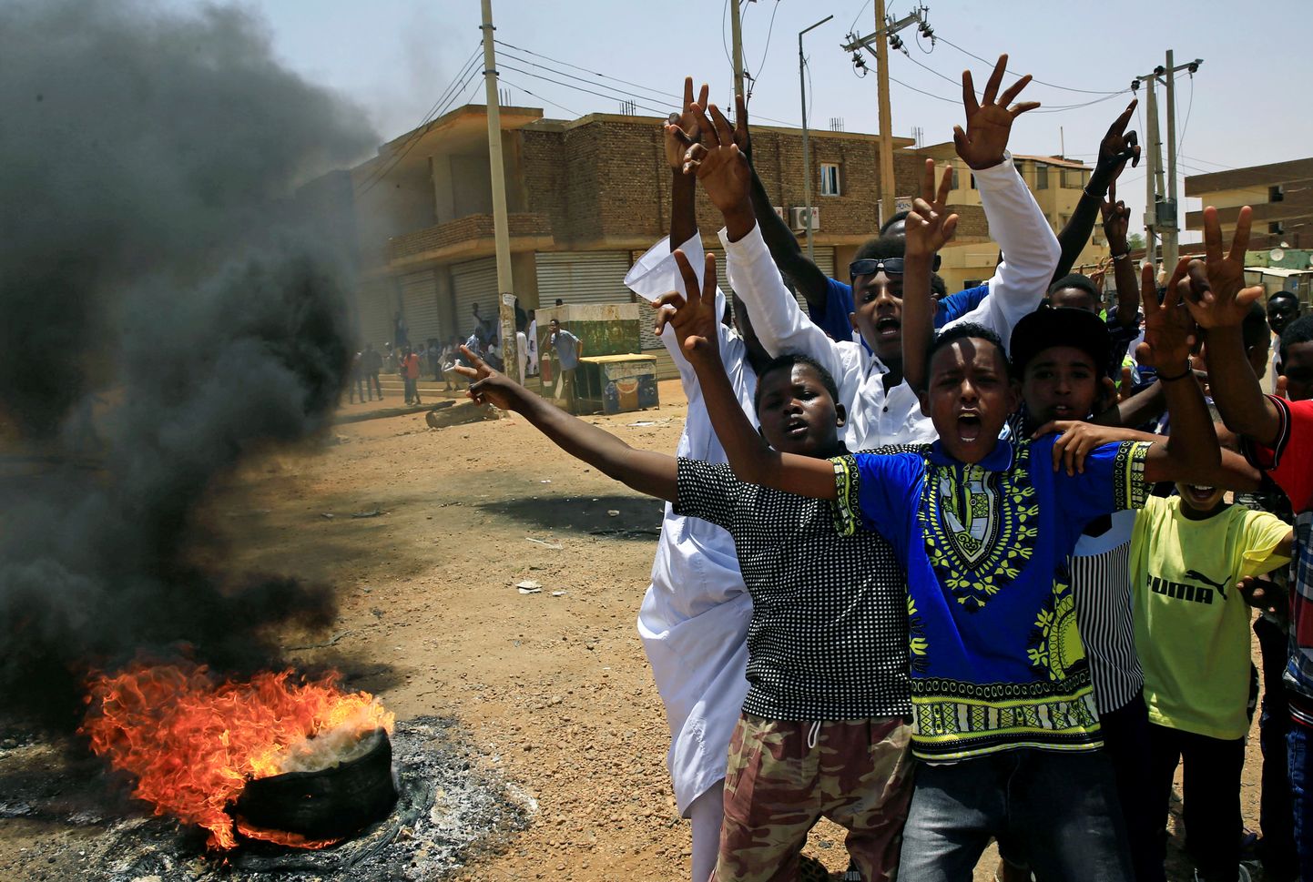 Sudaani meeleavaldajad hõikavad leegitseva teetõkke ees loosungeid.