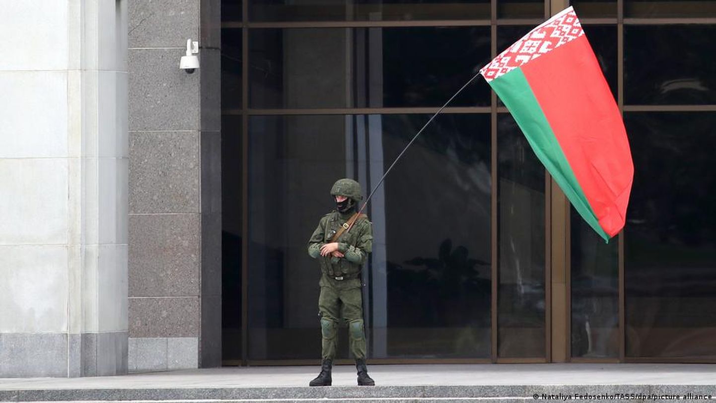 Человек в форме с государственным флагом Беларуси