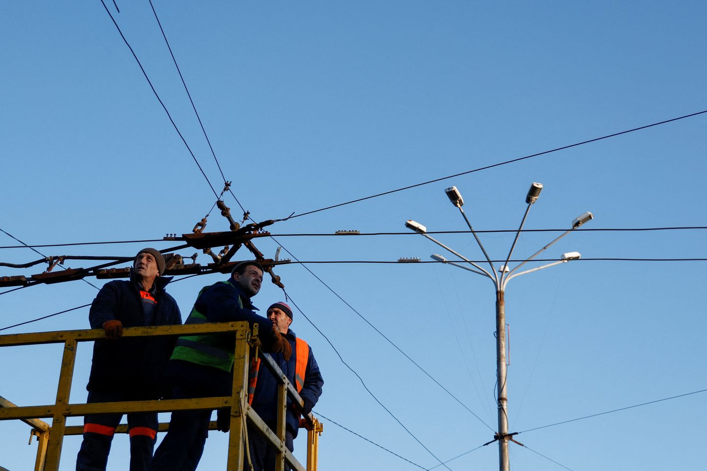 Kohaliku omavalitsuse töötajad kontrollivad avaliku transpordi elektrisõlme enne elektri väljalülitamist Mõkolajivis.