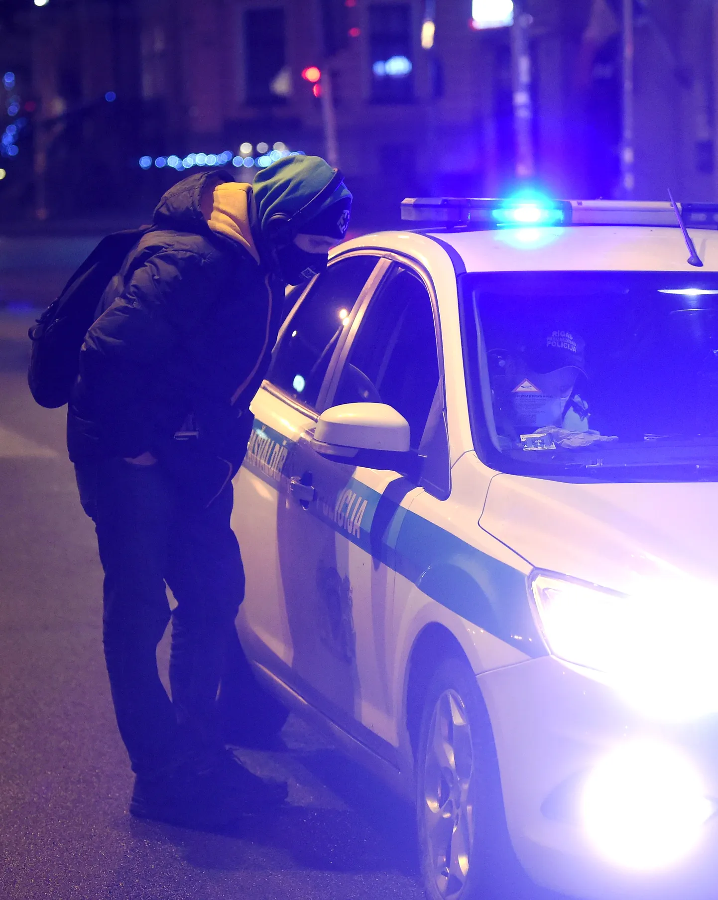 Rīgas pašvaldības policijas darbinieki reida laikā kontrolē, kā tiek ievēroti jaunie komandantstundas ierobežojumi, kad valstī izsludināta ārkārtējā situācija Covid-19 pandēmijas laikā.
