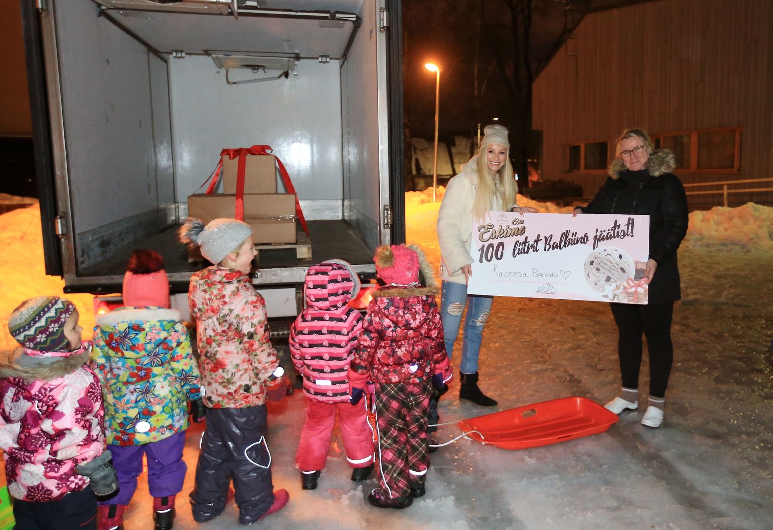 Anna Grace Saar ja Pisipesa perevanem Marina Kull ning Käopesa lapsed ja väike külmikauto, milles punase lindiga kinniseotult 100 liitrit jäätist.