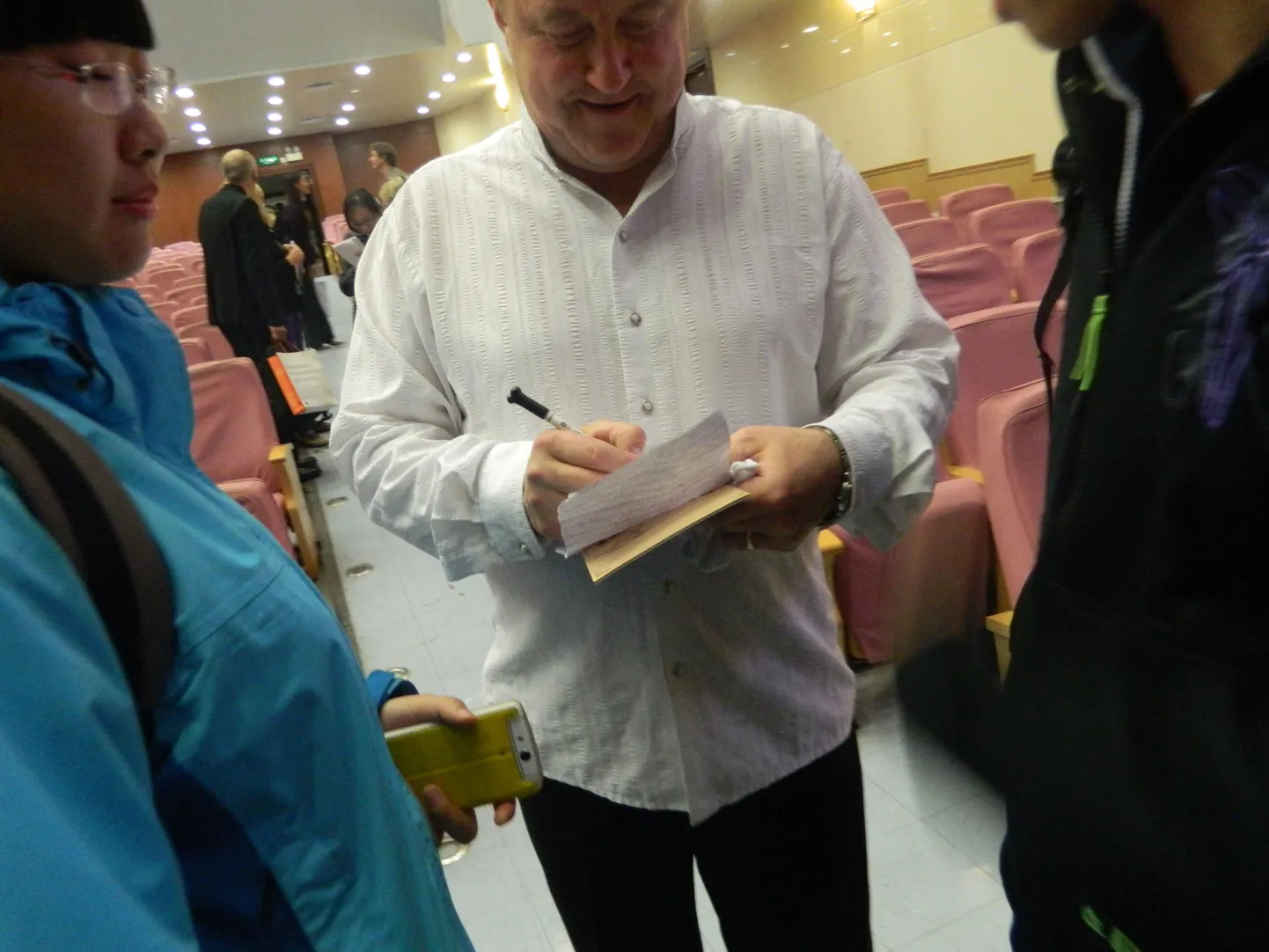 Käsikellade ansambli Arsis kontsert Pekingis. Aivar Mäe annab innukatele hiinlastele autogramme.