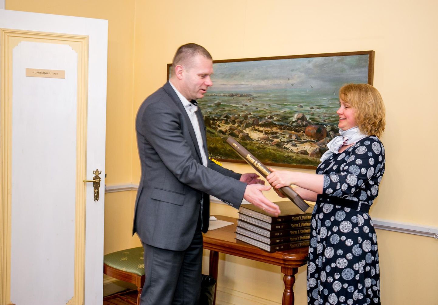 Pärnu Postimehe arvamustoimetuse juhataja Siiri Erala annab linnapea Romek Kosenkraniusele üle eelmise aasta lehenumbrid.