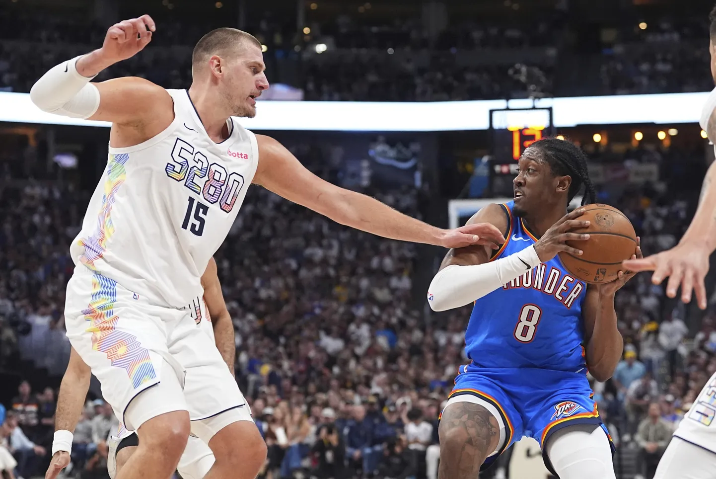 Denver Nuggetsi mängija Nikola Jokic (vasakul) ja Oklahoma City Thunderi mees Jalen Williams (paremal) palliga rünnakul.