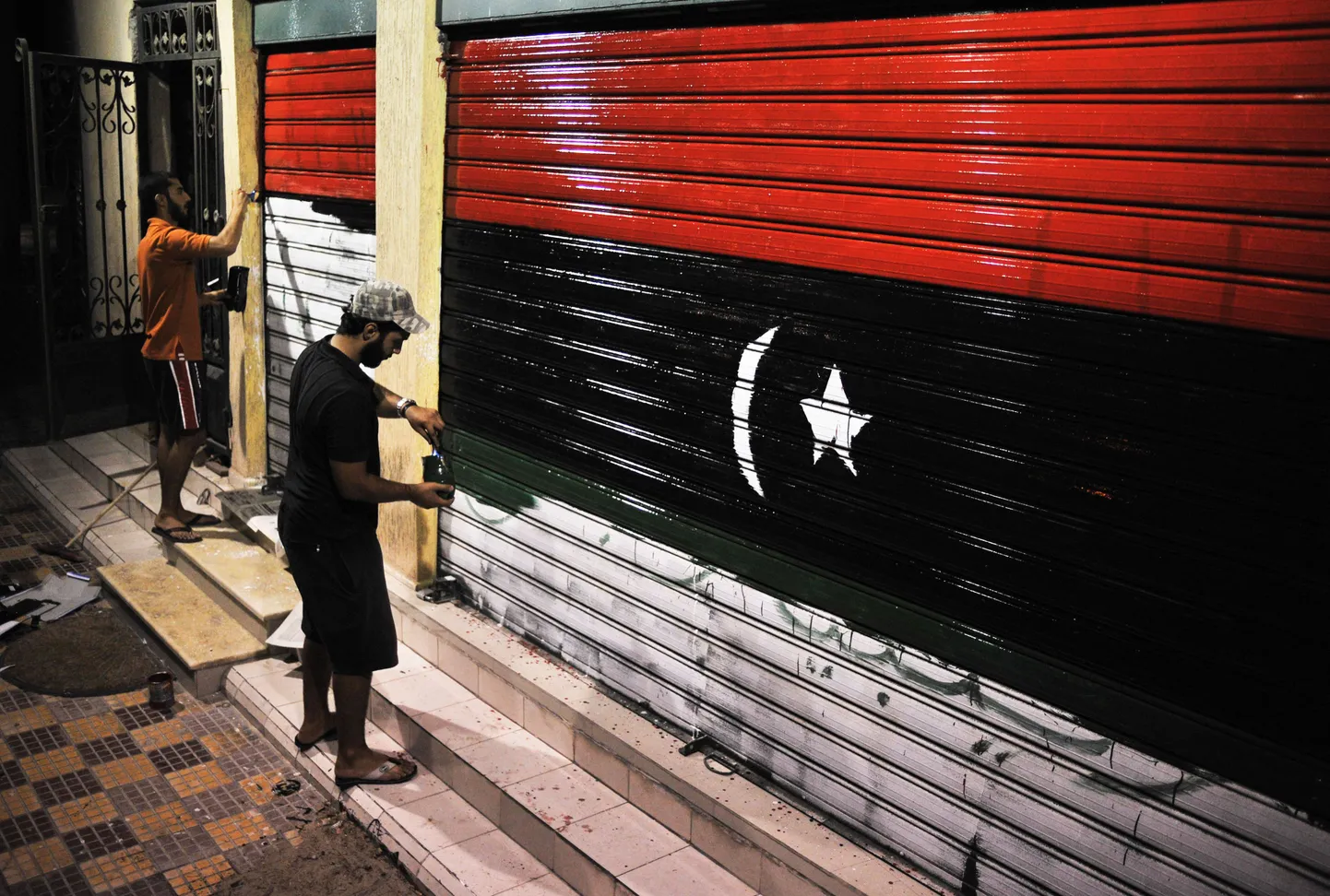 Mehed värvivad ust selliseks, nagu on ülestõusnute lipp Liibüas. Pilt on tehtud Lääne-Liibüas Zuwaras.
