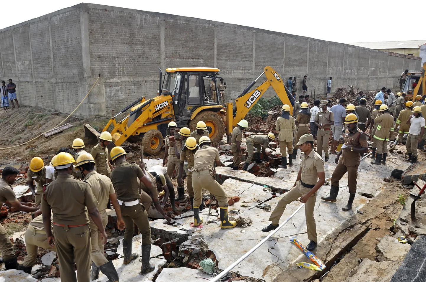 India päästetöötajad täna kokkuvarisenud müüri rususid koristamas.