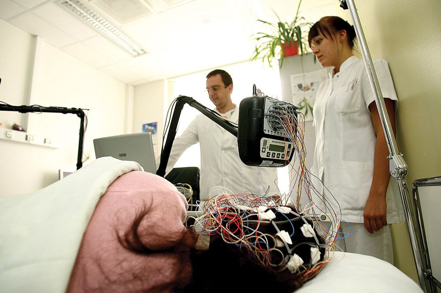 Tartu Ülikooli Kliinikumi EEG-uuringu ambulatoorses kabinetis jälgivad neuroloog Aleksei Rakitin ja õde Gerli Visnapuu, kuidas nende elektroodidega varustatud patsiendil seal läheb.
