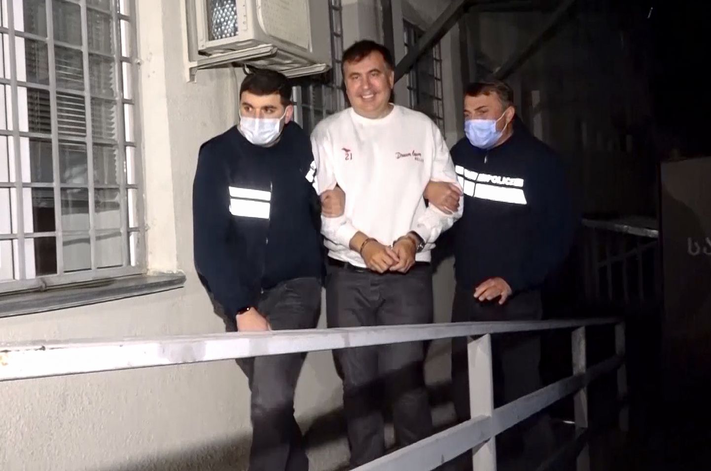 Gruusia politsei eskordib kinnivõetud ekspresidenti Mihheil Saakašvilit.