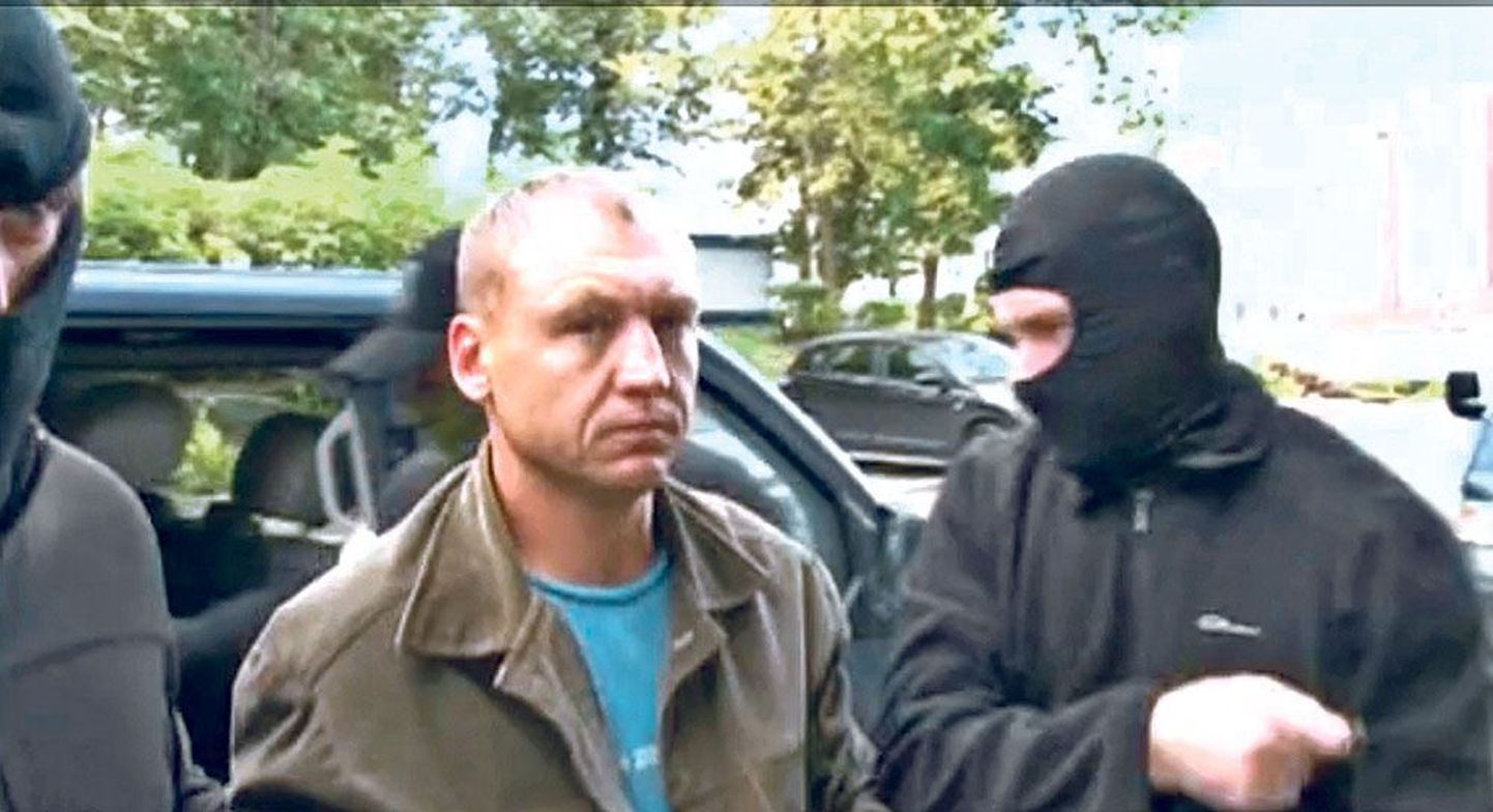 Maskides mehed Eston Kohvrit Moskvas asuvasse kohtumajja eskortimas.