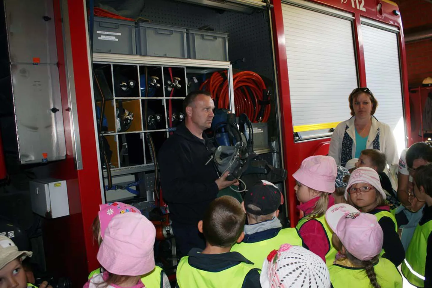 Päästekomando juhtivpäästja Antti Lääts näitab lastele päästeautode varustust.