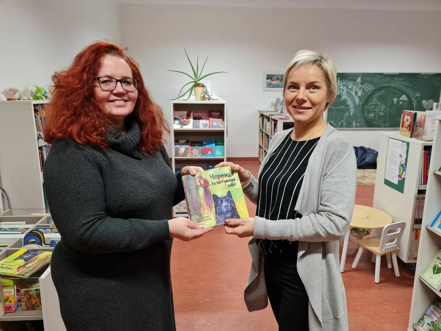 Türi raamatukogu direktor Astrid Karpender (paremal) ülteb Tiina Lippantilt üllatuskinki vastu võttes, et kindlasti leiab raamat Mustika seiklustest tänulikke lugejaid.