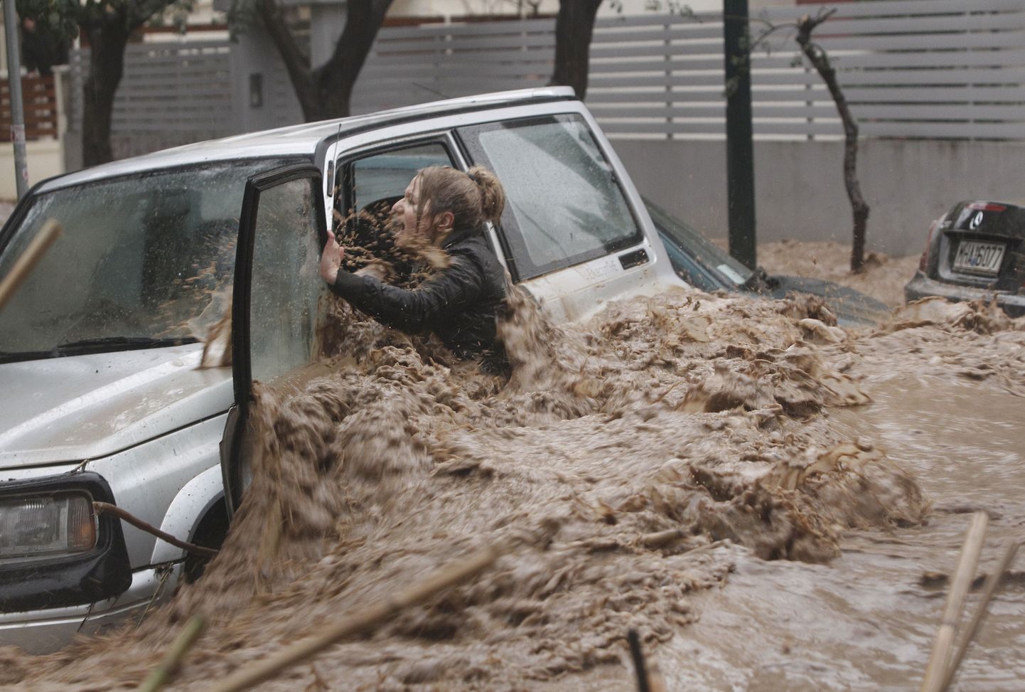 Naine püüab välja tulvavete meelevalda jäänud autost Ateena eeslinnas  Chalandris.