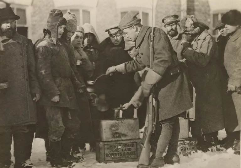 Военнопленные получают питание из рук американского солдата. Архангельск, 1918