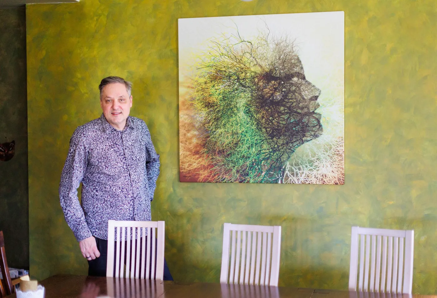 Pilt räägib rohkem kui sõnad: kunstnik Nerva oma kodus, seinal isikliku seosega teos.