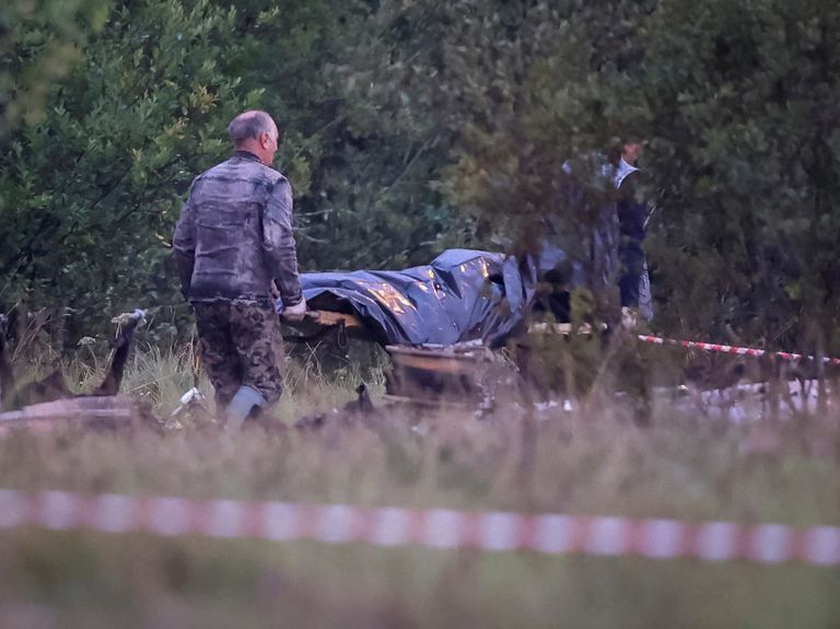 Спасатели везут тело одного из погибших на месте крушения бизнес-джета Евгения Пригожина. 24 августа 2023.