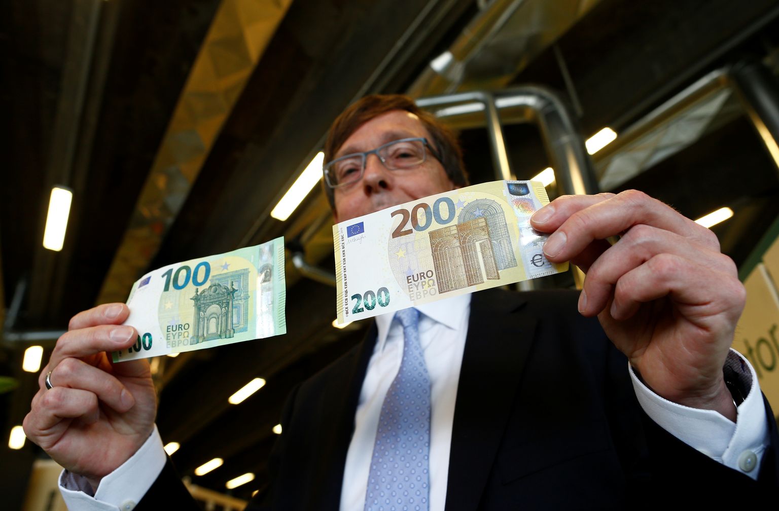 Директор по банкнотам Европейского центрального банка (ЕЦБ) Тон Роос показывает новые банкноты номиналом 100 и 200 евро в секретных хранилищах Банка Италии в Риме, 21 мая 2019 года.