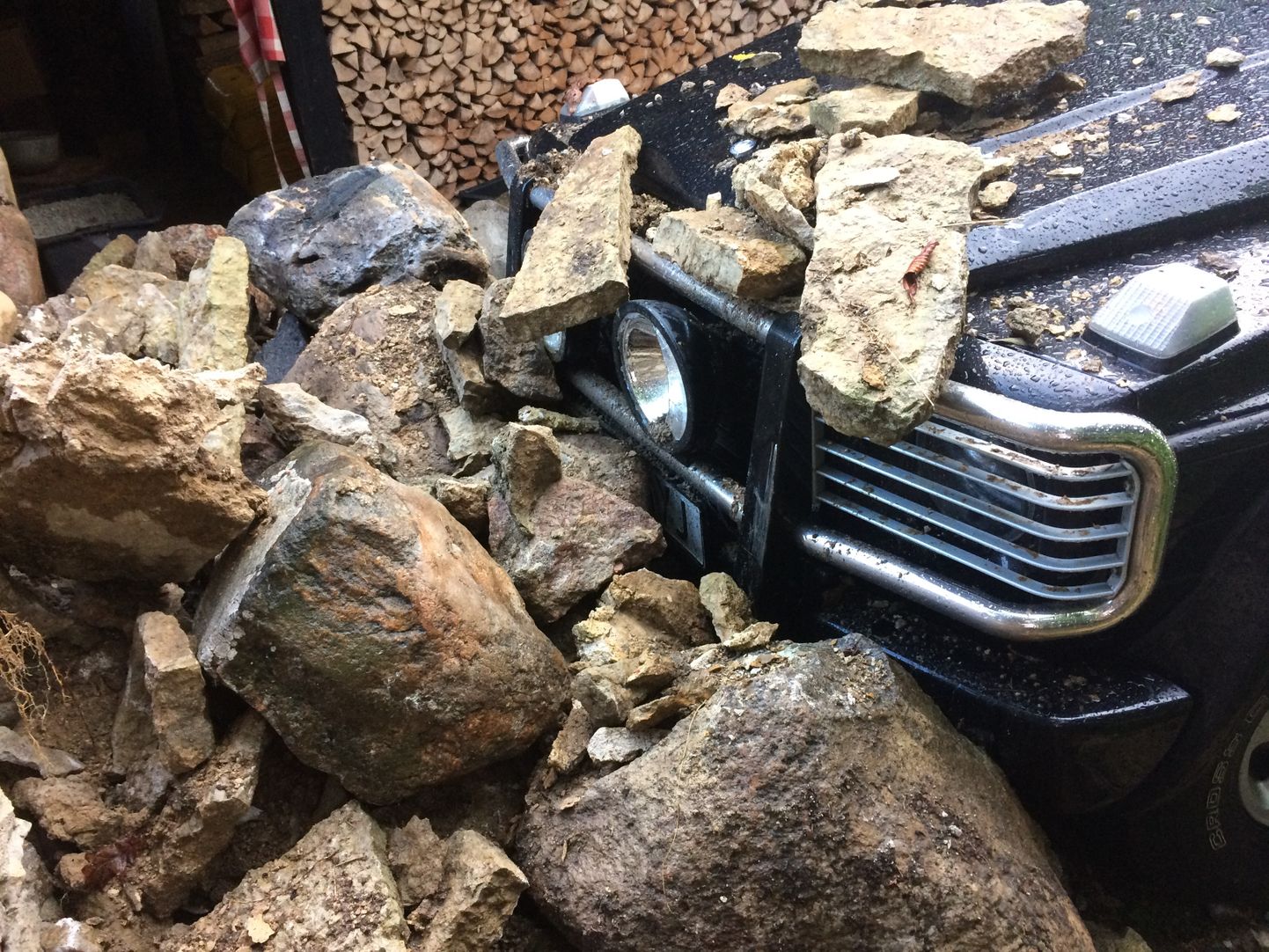 Kokku varisenud kivimüüri alla jäänud auto.