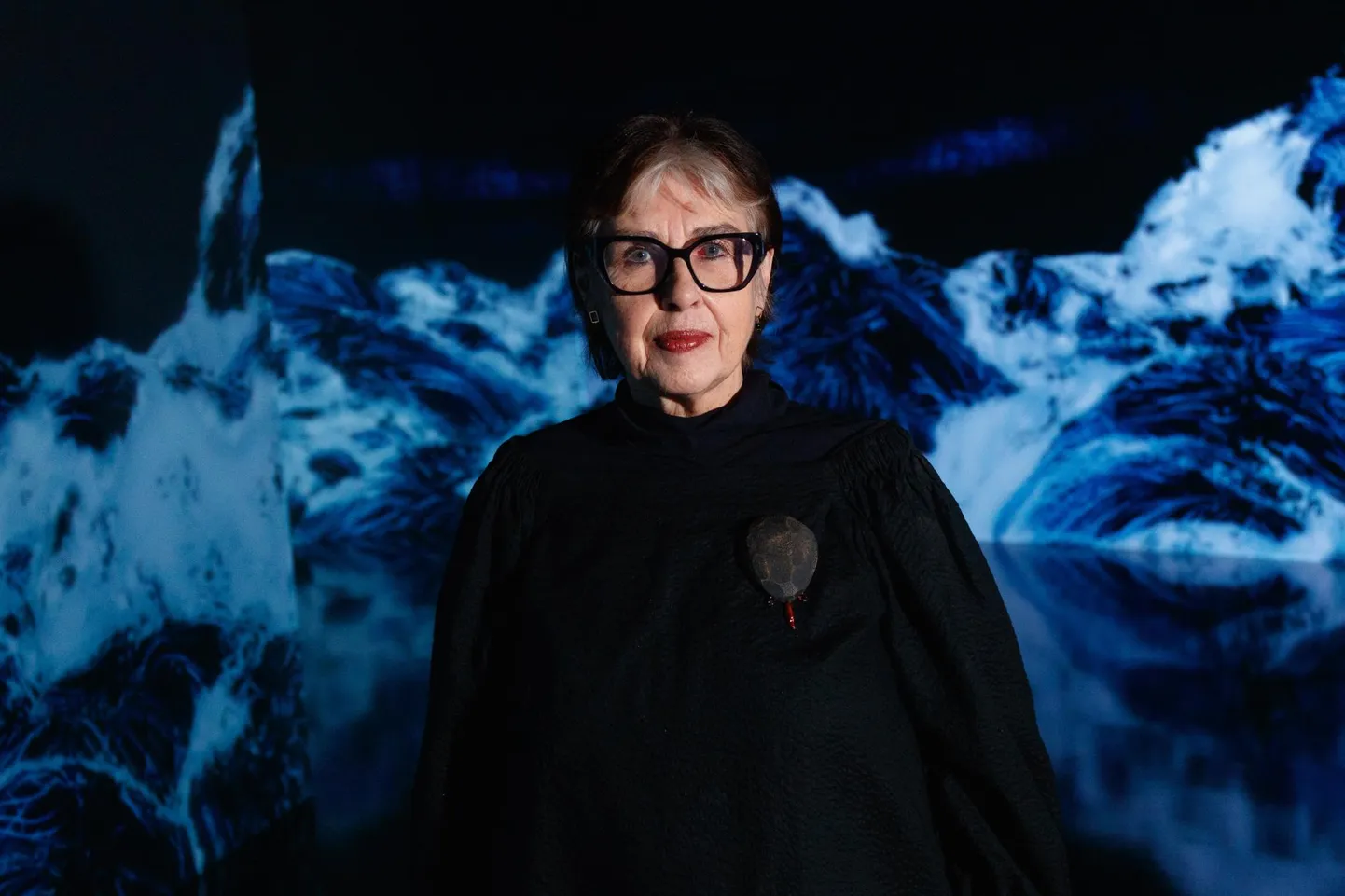 Sirje Helme Kumus teamLabi installatsiooni «Mustad lained. Immersiivne mass» keskel.
