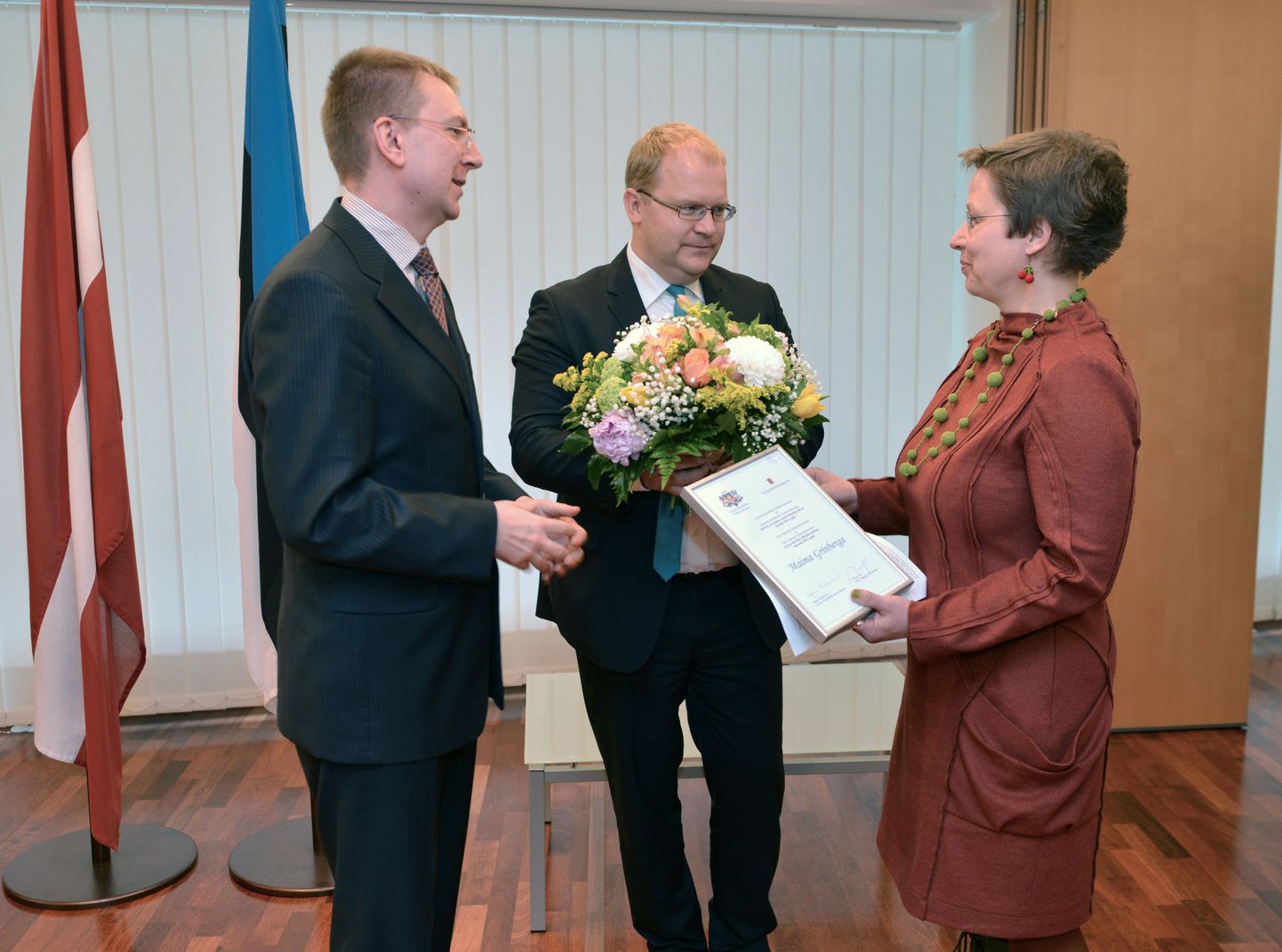 Välisminister Urmas Paet ulatab Maima Grīnbergale lillebuketi.