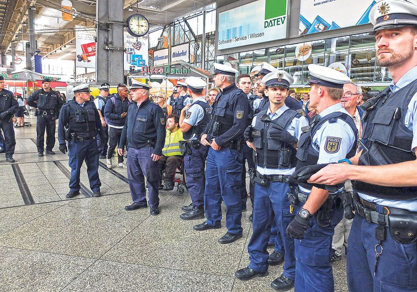 Мюнхенские полицейские следят, чтобы   все беженцы сели в поезд до Дюссельдорфа.