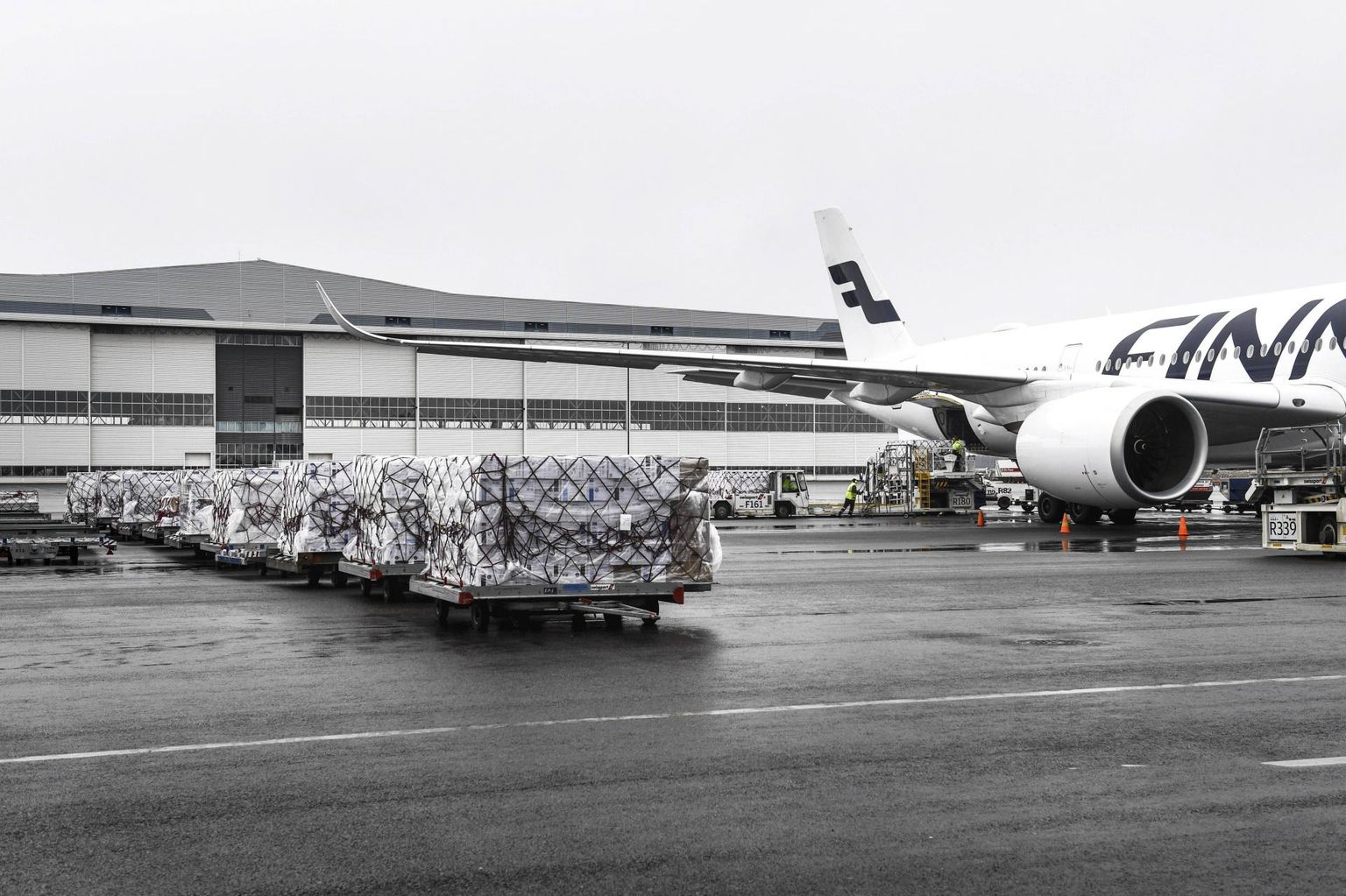Töölised Helsinki-Vantaa lennujaamas Finnairi kaubalennukiga Hiinast saabunud meditsiinivarustust maha laadimas.