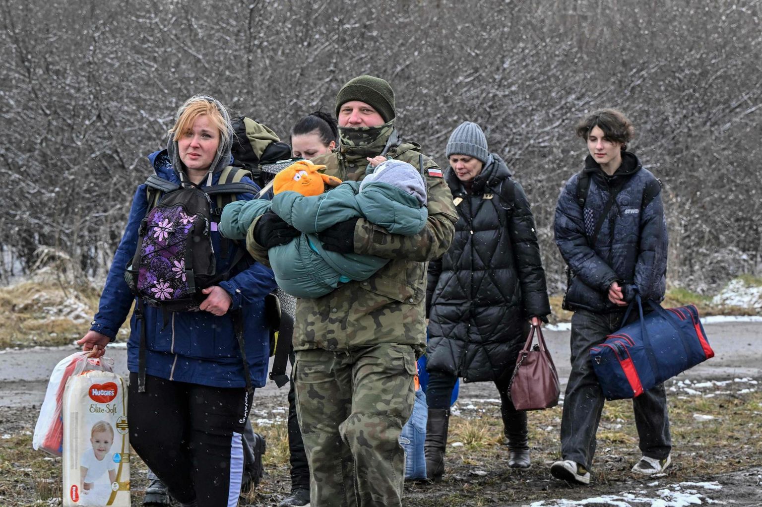 Poola piirivalvur abistamas Ukrainast tulevaid sõjapõgenikke üle Medyka piiripunkti.