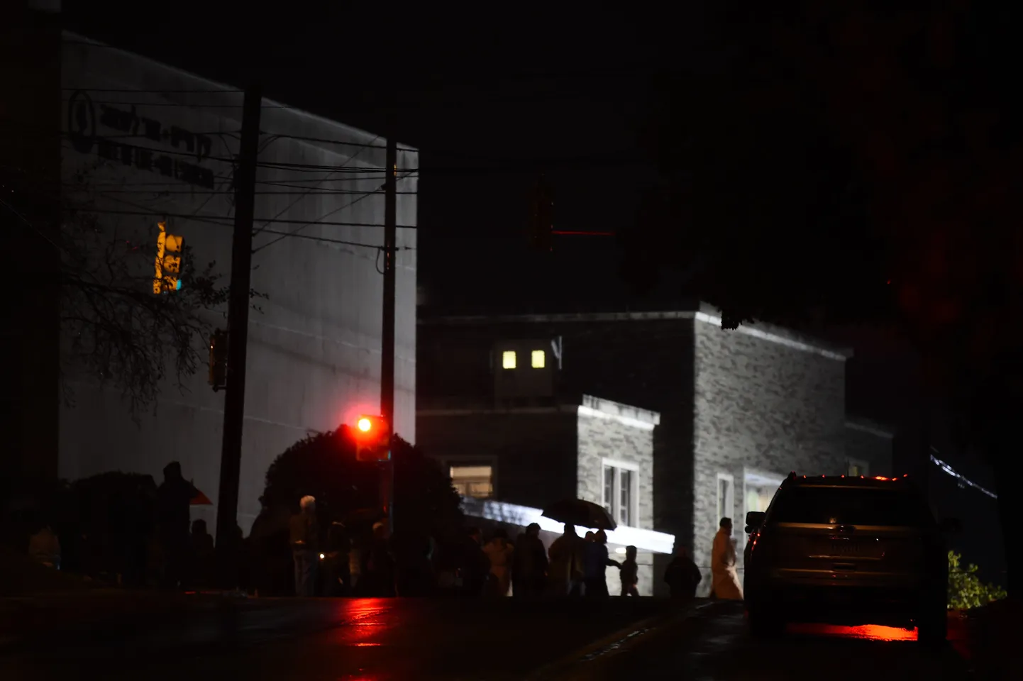 People stand outside the Tree of Life Synagogue after a shooting there left 11 people dead in the Squirrel Hill neighborhood of Pittsburgh on October 27, 2018. - A heavily armed gunman opened fire during a baby-naming ceremony at a synagogue in the US city of Pittsburgh on October 27, killing 11 people and injuring six in the deadliest anti-Semitic attack in recent American history. (Photo by Brendan SMIALOWSKI / AFP)