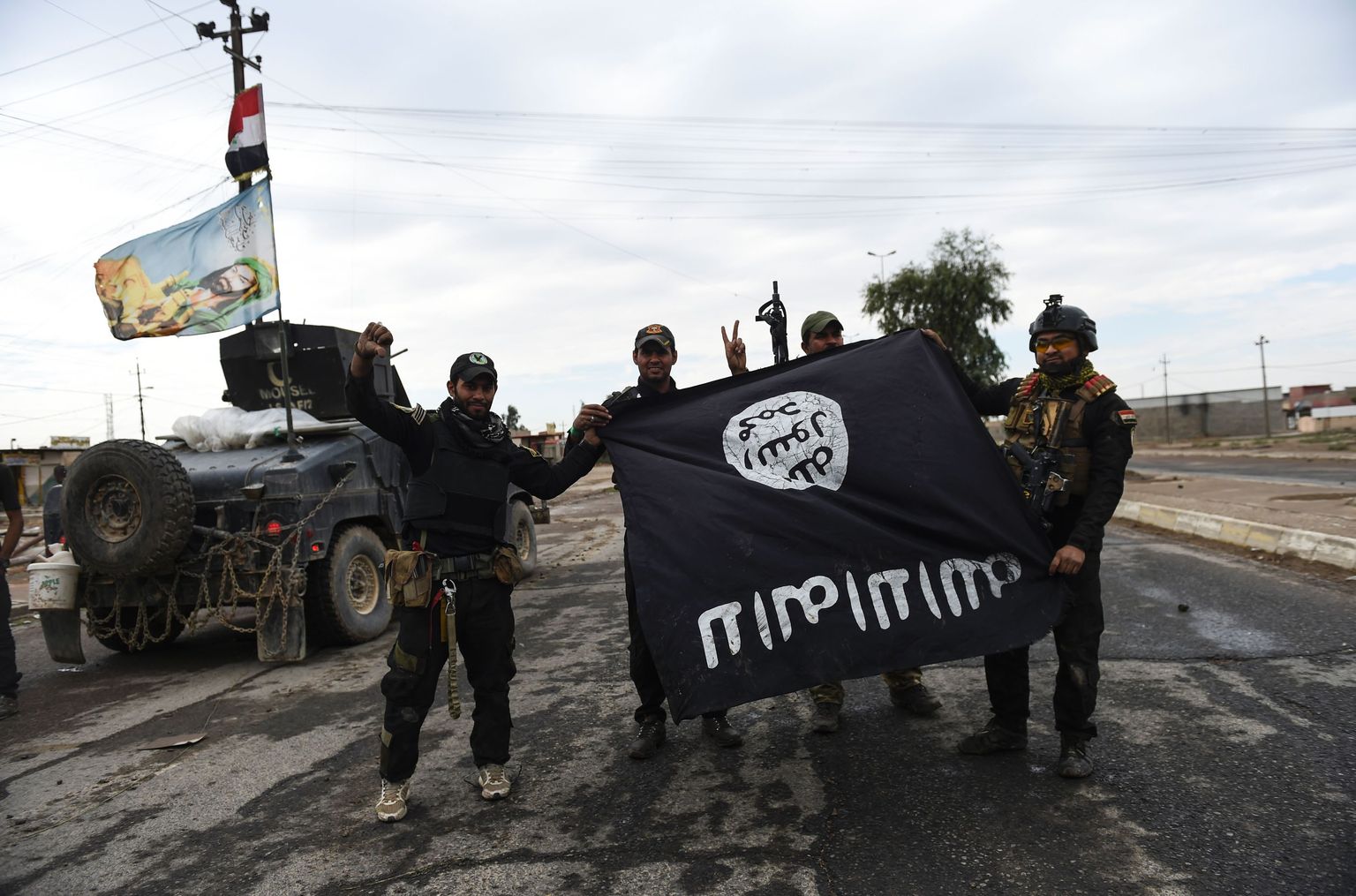 Iraagi sõdurid poseerivad islamistidelt võetud lipuga Gogjalis.