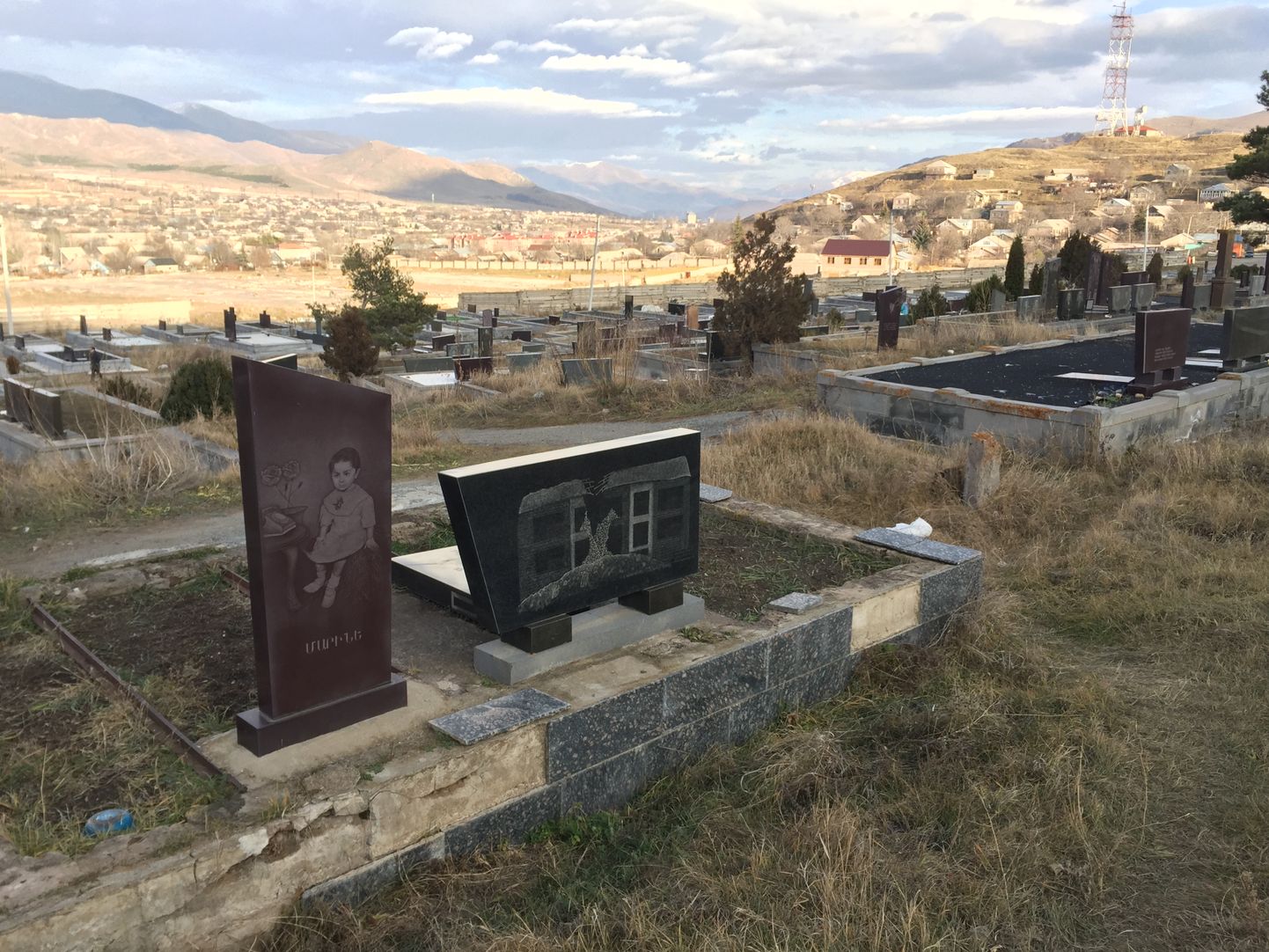 Кладбище, где похоронены жертвы землетрясения, смотрит на бывший промышленный район Спитака.