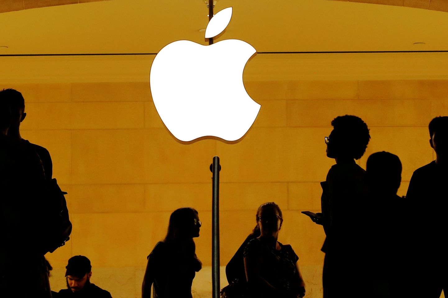 Люди на фоне логотипа Apple
