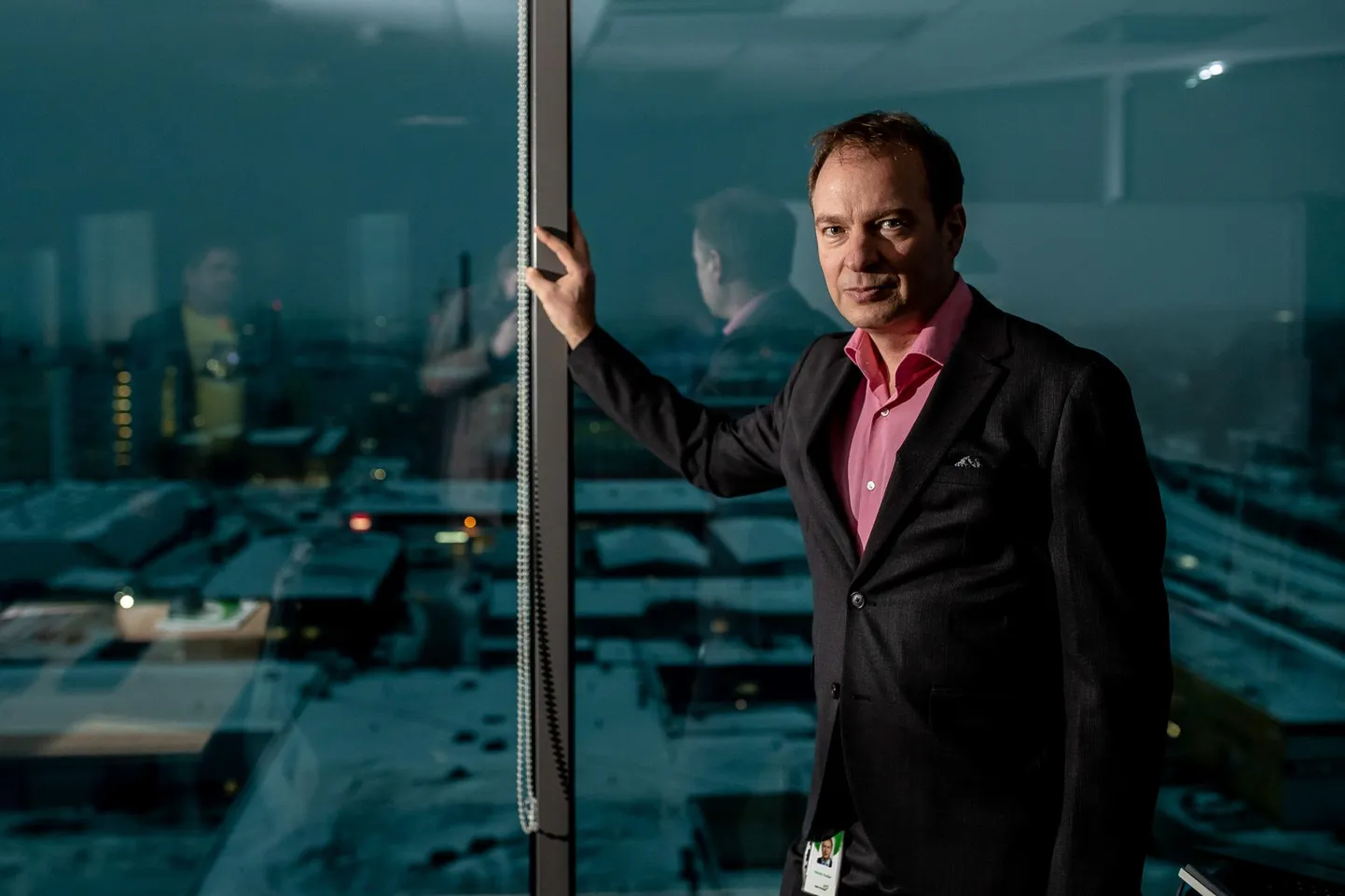 Руководитель Eesti Energia Хандо Суттер в своем офисе на 12 этаже. За его спиной туманный Таллинн, где, как кажется, не горит ни одна лампочка.