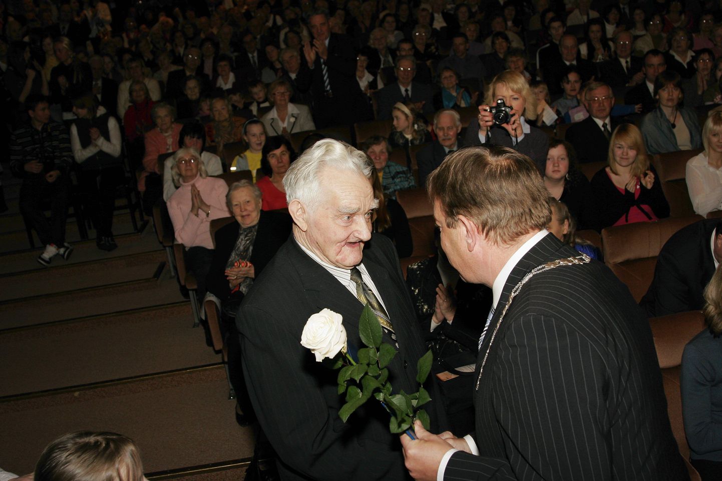 Pensionär Olav Seppo sai linnajuhtidelt tänukirja ja valge roosi.