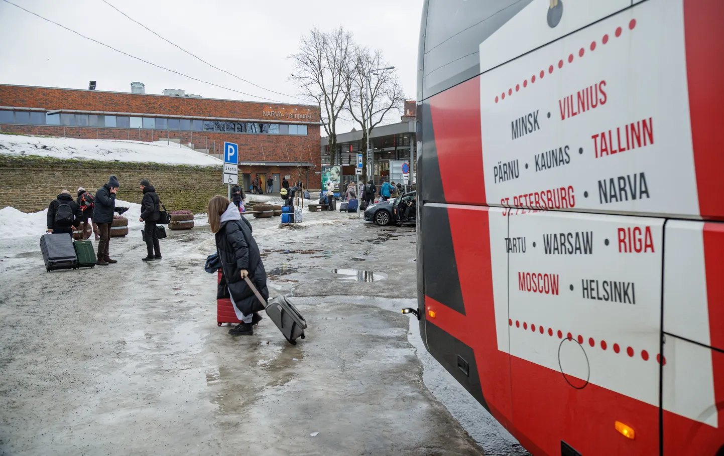 Пассажиры около международного автобуса одной из компаний, которые продолжают рейсы в Россию, Нарва, 2024 год.