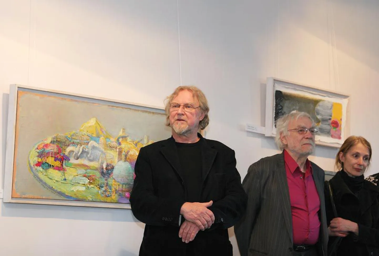 Maalikunstnik Tiit Pääsuke tutvustab Viljandisse toodud näituse lugu. Tema selja taga on akrüülmaal «Itaalia palett veiniklaasiga». Paremal seisab kunstnikepaar Rita Raave ja Enn Põldroos.