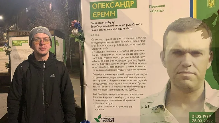 Сергей Еремич возле стенда, который посвящен его отцу — Александру Еремичу, которого расстреляли россияне три года назад, за несколько дней до освобождения Бучи