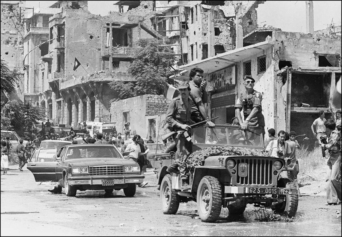 A French forces military jeep with Palestinian fighters on board precedes the motorcade of Palestine Liberation Organisation (PLO) chairman Yasser Arafat on August 30 1982 as he leaves the Israeli-occupied Lebanese capital Beirut for Tunis.