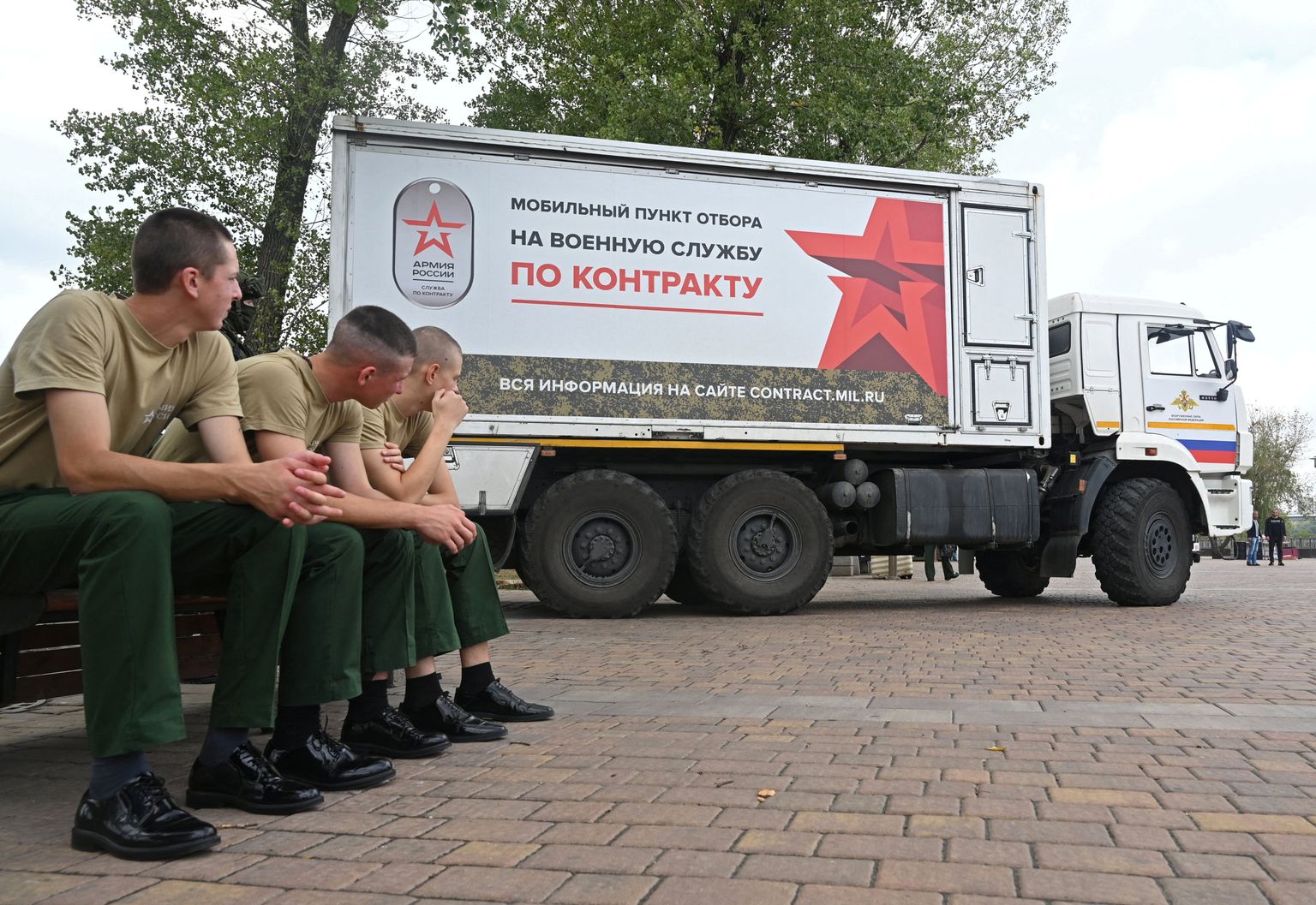 Российские военнослужащие сидят рядом с мобильным призывным пунктом для прохождения военной службы по контракту в Ростове-на-Дону, Россия, 17 сентября 2022 года